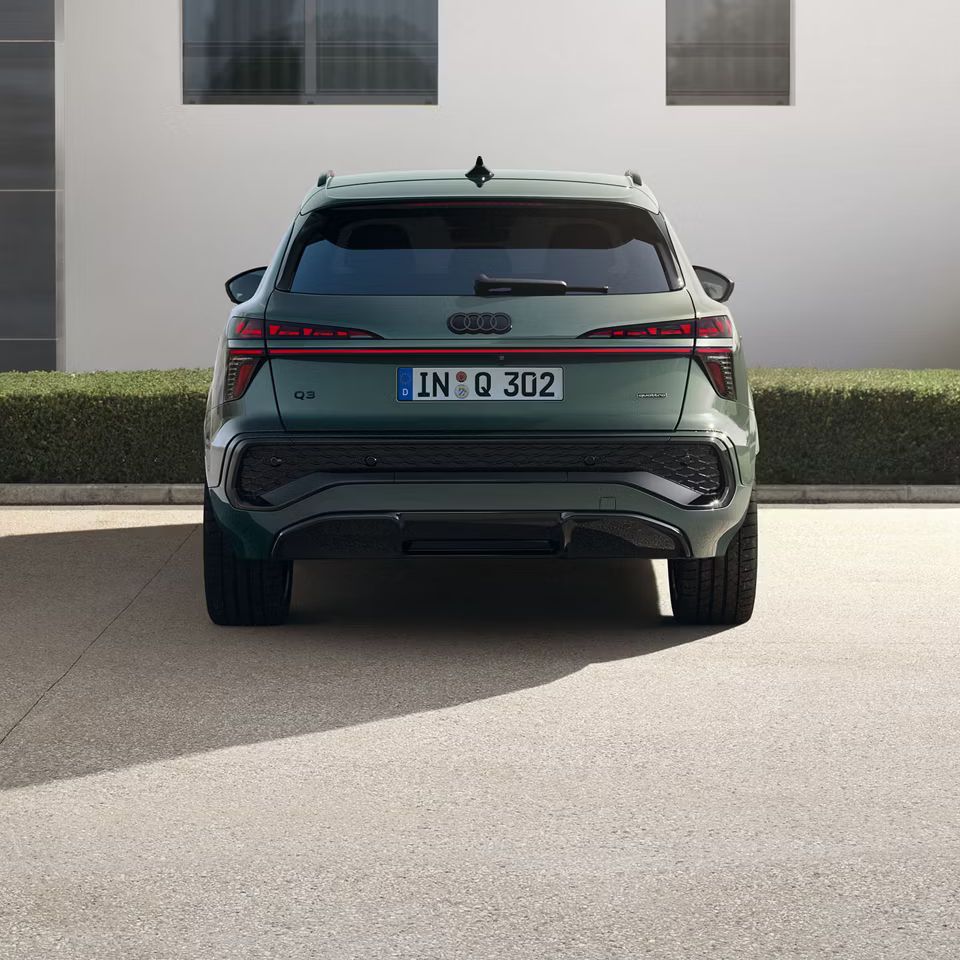 Hátulról egy házfal előtt parkoló Audi Q3 terepjáró