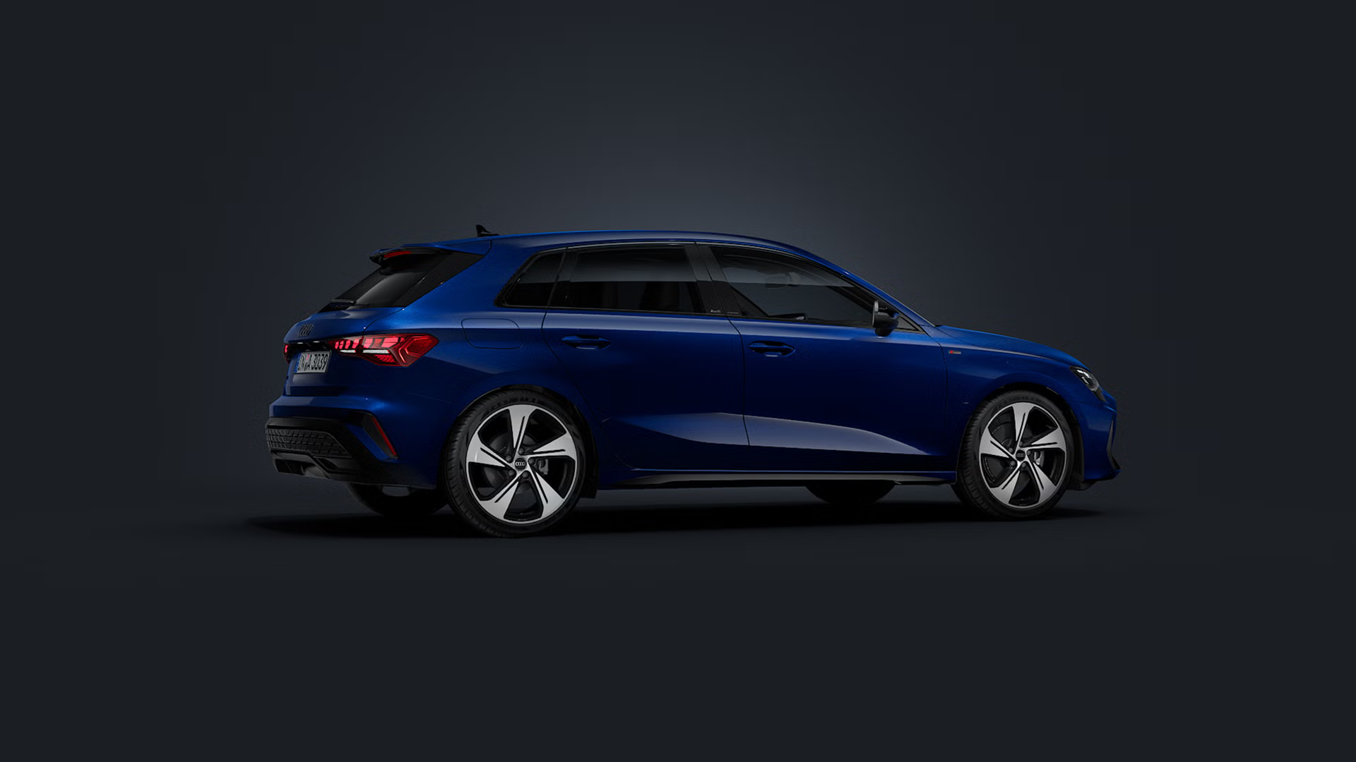 Der Audi A3 Sportback schräg von vorne auf dunklem Hintergrund.