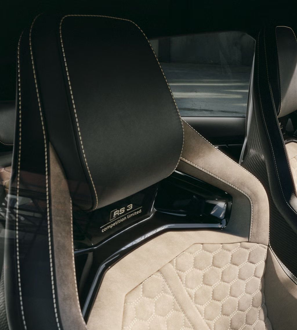 Nahaufnahme der RS-Schalensitze mit mit RS competition limited-Schriftzug und Wabensteppung in Ingwerweiß.