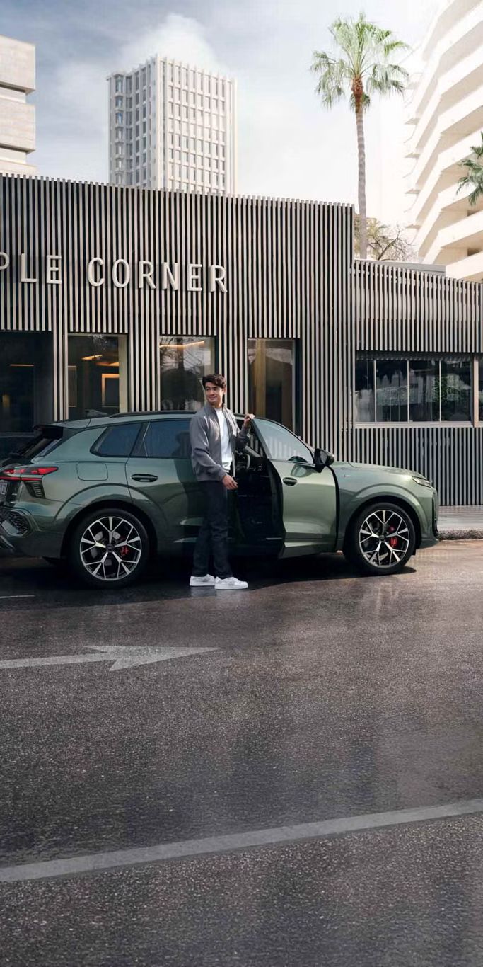 Zöld AUDI Q3 modellből száll ki egy férfi