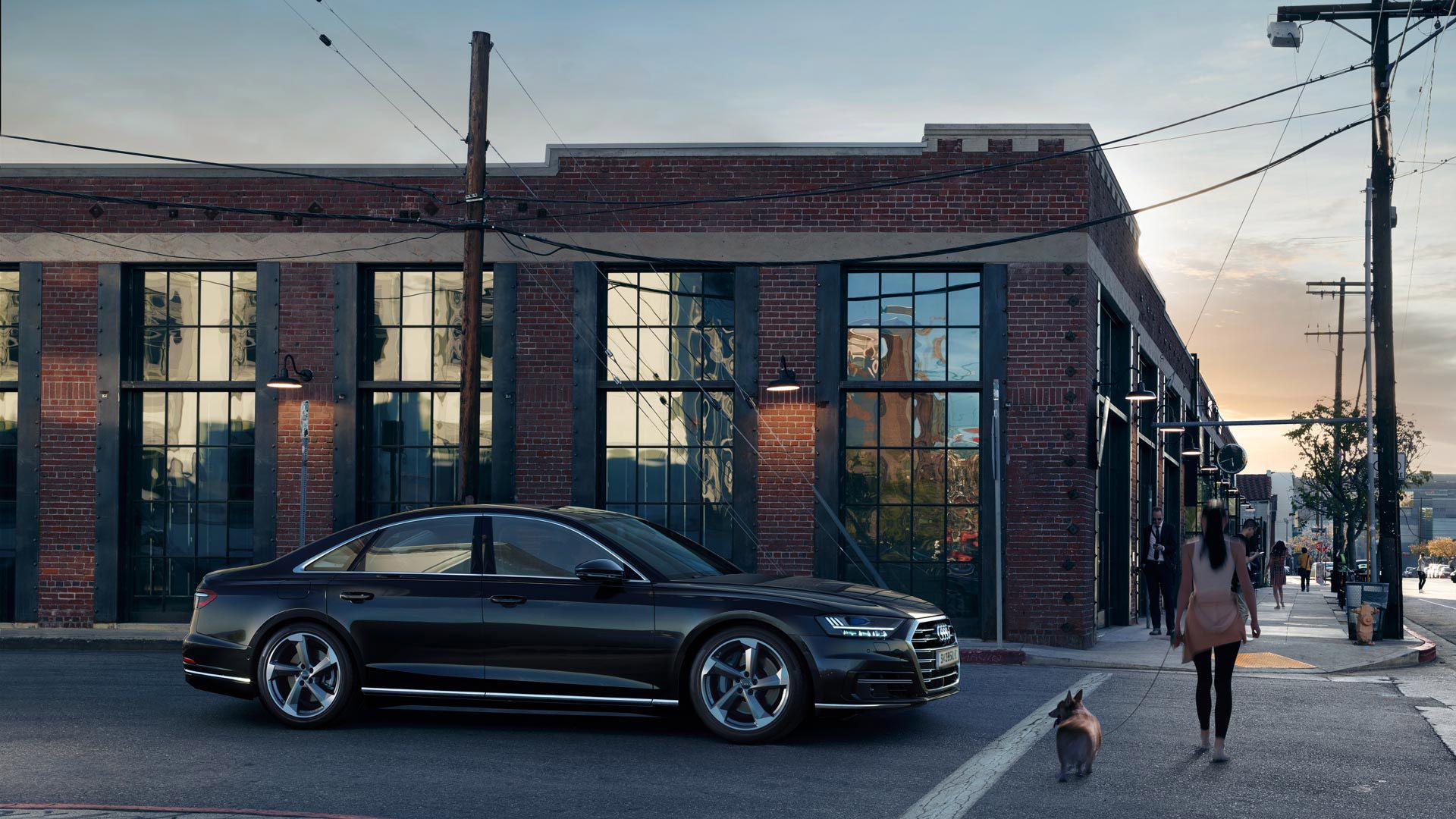 Audi modell egy téglaház előtt
